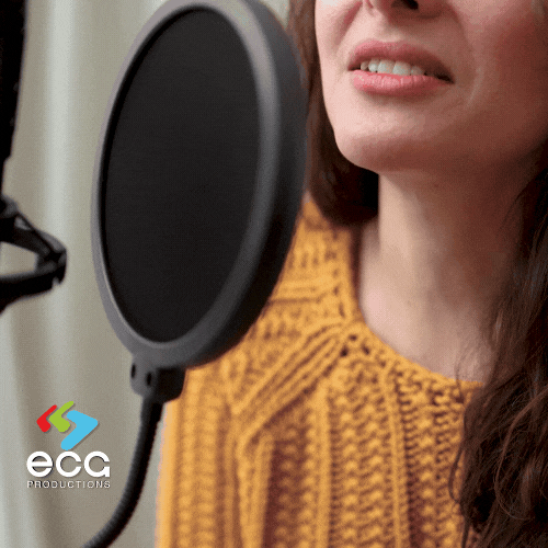 A White woman performs a voiceover session in a recording studio, showcasing the clarity and professionalism of voiceover artists in media production
