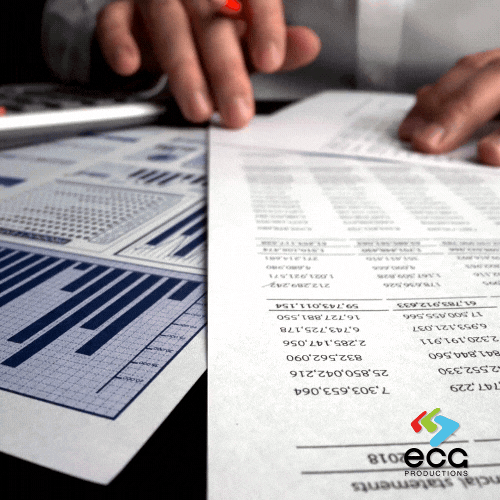 A hand scans a detailed budget and marks it for reconciliation, demonstrating the precision required in video budgeting and financial tracking.