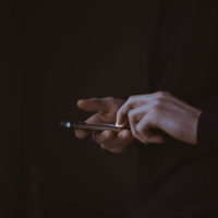 A man looks at social media and mobile video marketing on his iPhone.