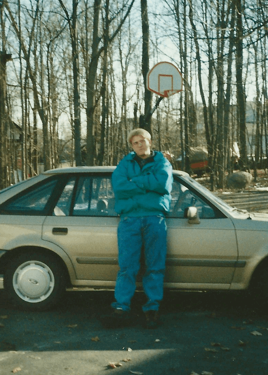 Jason-Sirotin-Poses-in-a-charlotte-hornets-jacket-next-to-an-89-ford-escort