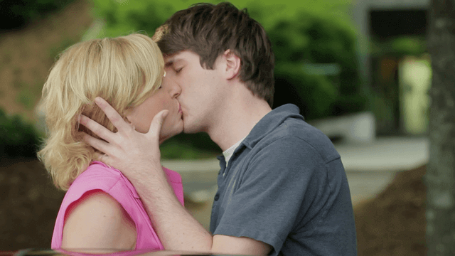 Younger man kisses older woman