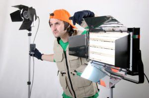 production crew member working with lights and lighting equipment