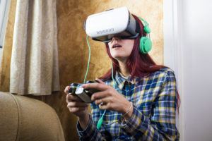 woman wearing virtual reality goggles or glasses playing a videogame