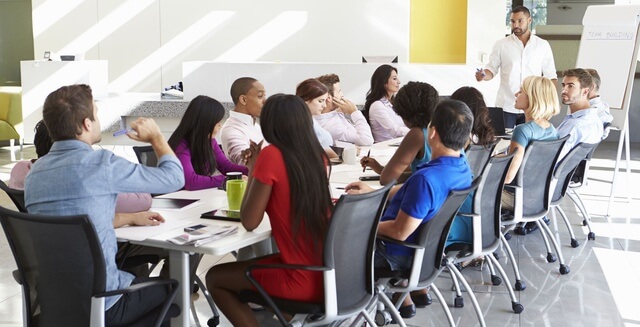 31047565 - businessman addressing meeting around boardroom table