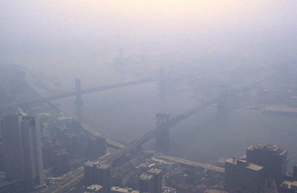 Grayish aerial view of NYC while smog diffuses the light