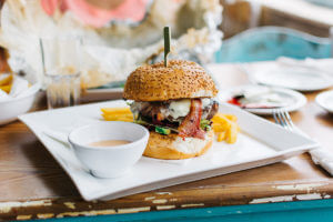 A cheeseburger with fries and dipping sauce.