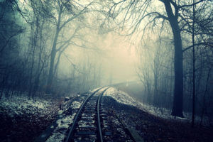 Hazy and snowy railroad track in woods like in scary movies and horror movies.