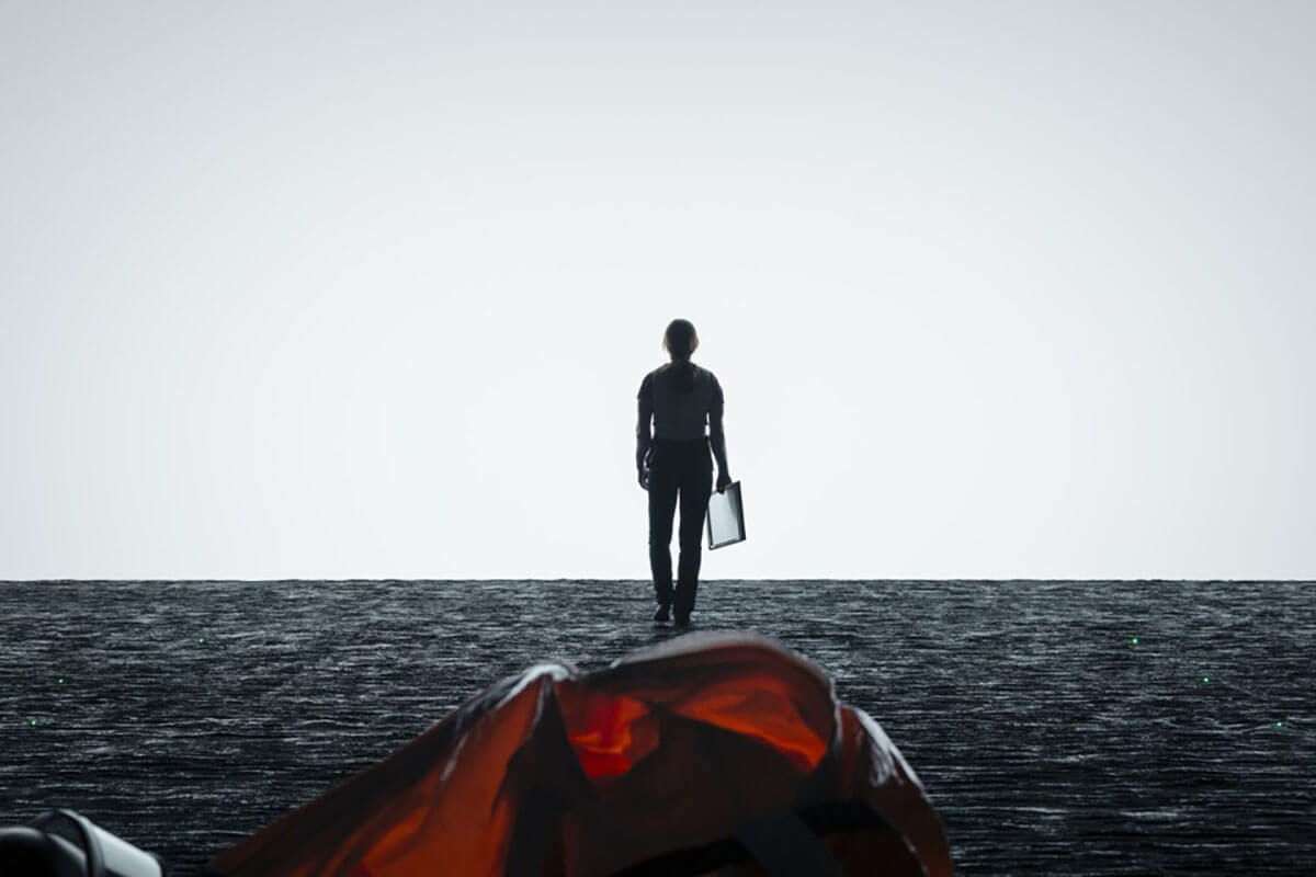 The silhouette of a woman facing a large white background inside a spaceship.