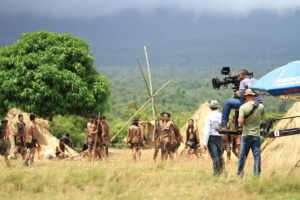 Location Scouting: A camera crew films on location as a tribe sets up new stick home and tipi locations.