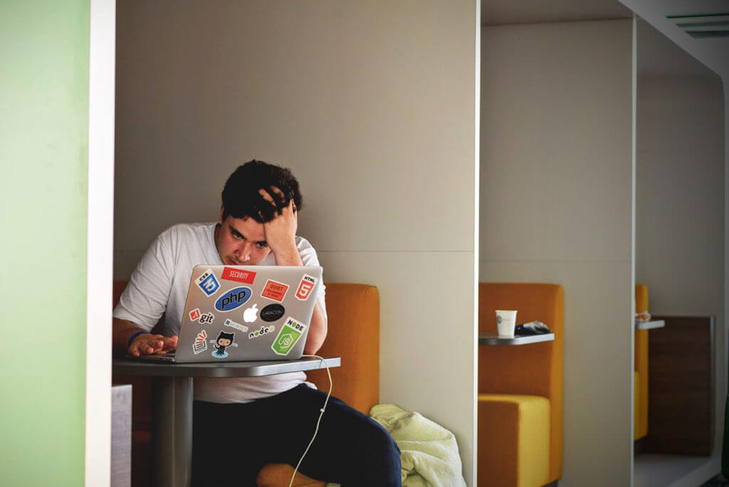 A frustrated and tired post-production team editor on his laptop.