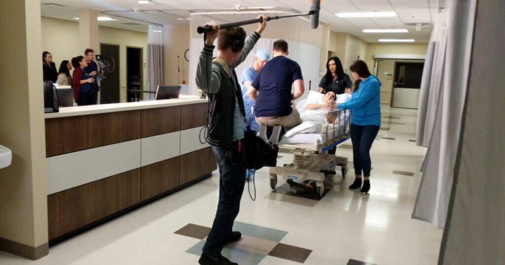 Brandon Peterson films a medical TV commercial on a gurney.