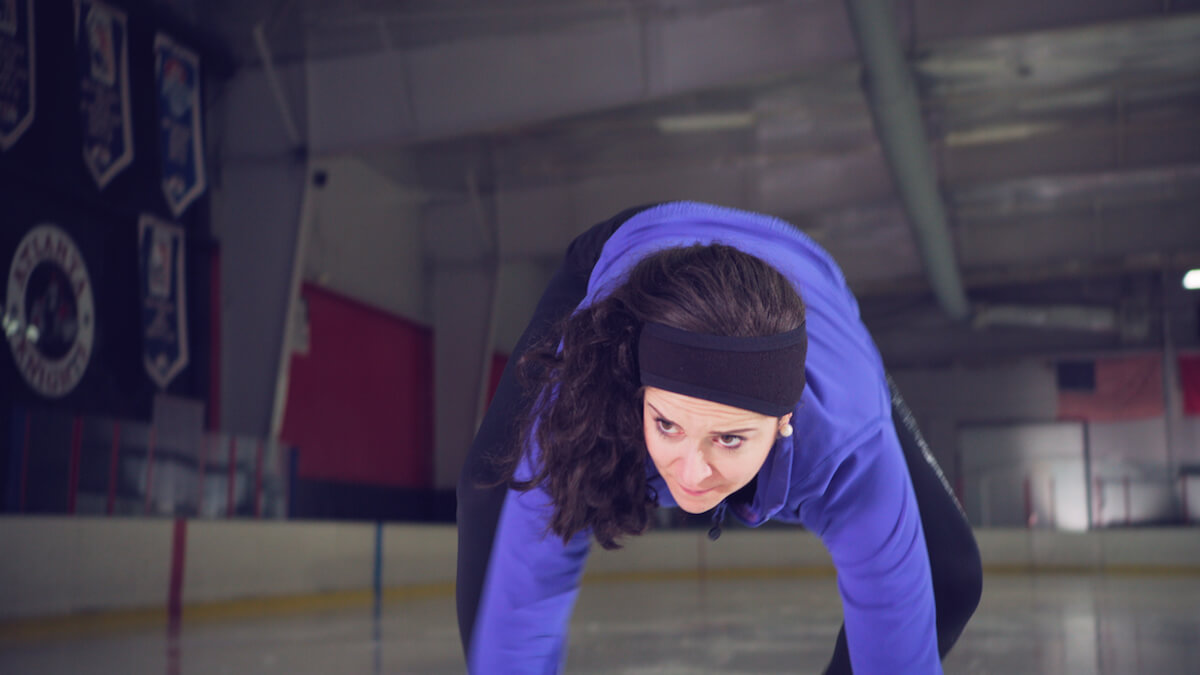 An ice skater gets up after a fall.