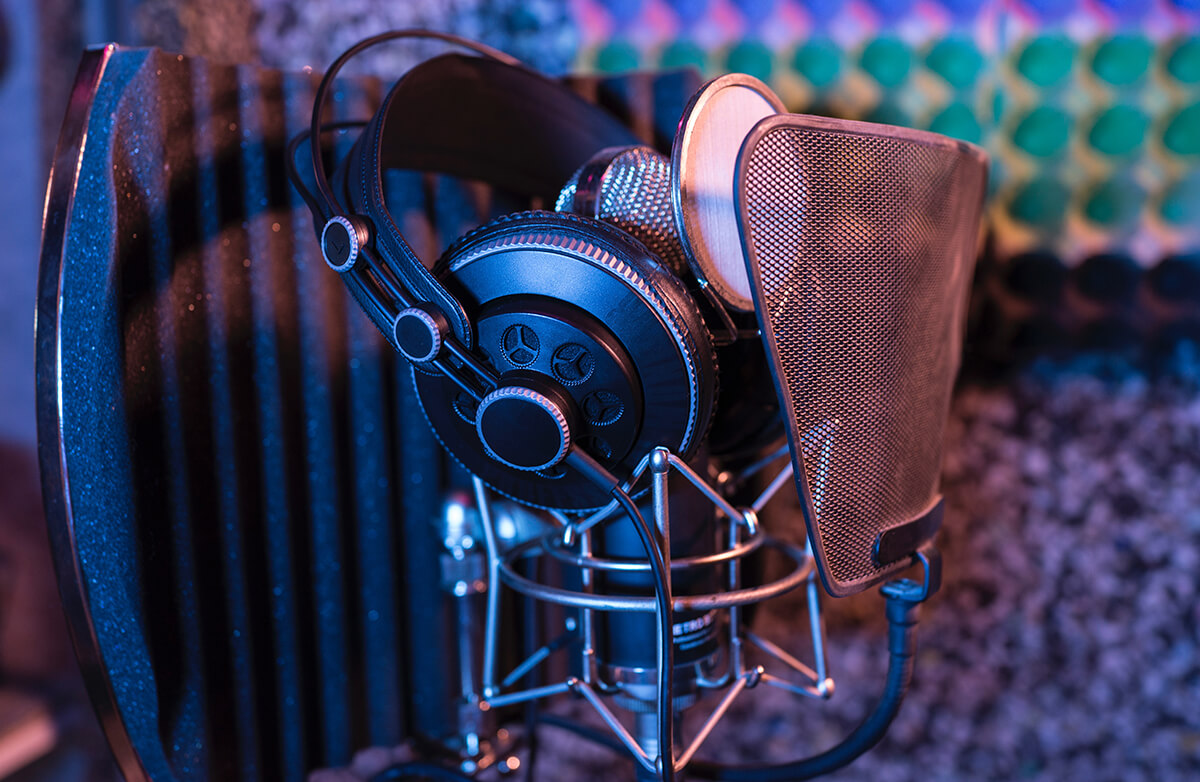 A sound booth, microphone, and headphones.
