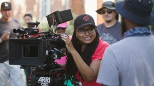 Ava Duvernay in a hat behind a camera.
