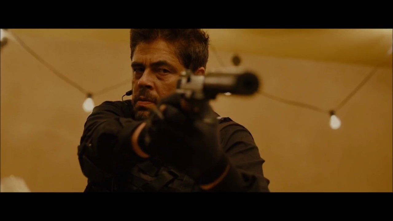 Benicio del Toro aims a gun in Taylor Sheridan's famous Sicario dinner scene.