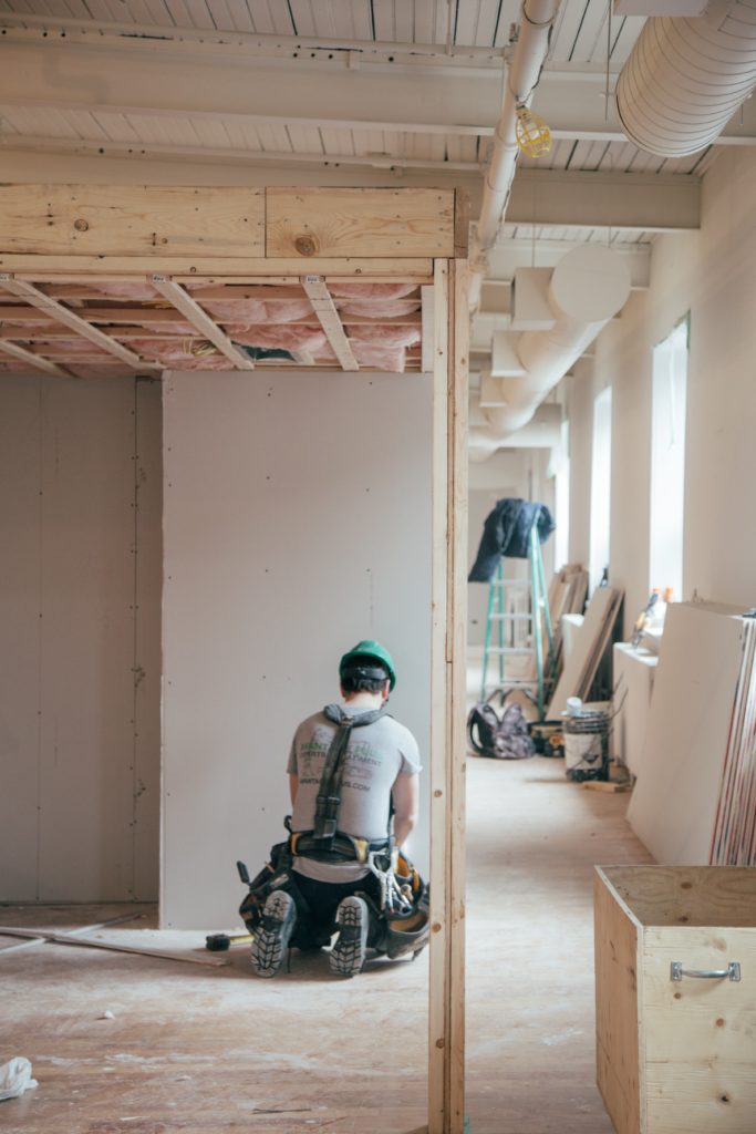 Set construction worker hanging drywall