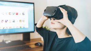 A woman looks into a VR headset to experience a concert remotely.