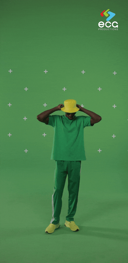 A man dressed in green stands in front of a green screen with motion tracking markers, demonstrating the setup for precise planar tracking in post-production.