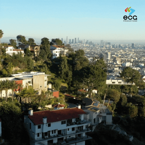 Los Angeles Fixer - View of hillside neighborhoods in Los Angeles, with rows of houses nestled among rolling hills under a clear blue sky. The serene landscape highlights the unique locations a 'LA fixer' might scout for film and TV productions, selecting residential backdrops that capture the essence of LA’s elevated neighborhoods and iconic hillside views.