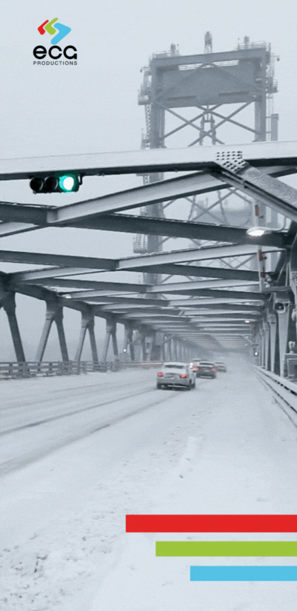 Snow-covered bridge in New Hampshire during an active snowstorm, with cars carefully crossing as thick snowflakes fall and blanket the landscape. This challenging winter scene captures the rugged beauty of New England's snowy weather—a type of location a 'New Hampshire fixer' might secure for film and TV, managing logistics to ensure safe filming and authentic seasonal atmosphere for winter scenes.