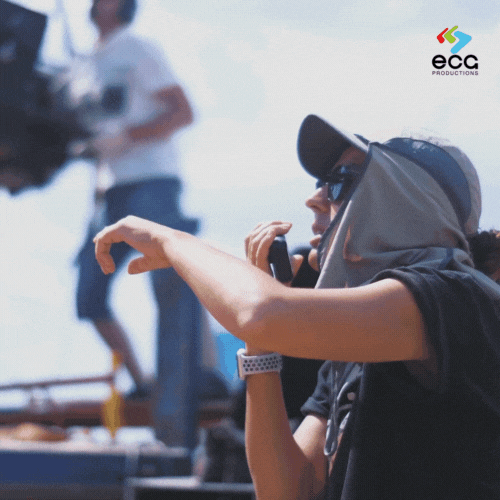 A Key Grip uses a walkie-talkie to call out crew instructions, emphasizing the leadership and coordination central to the Grip Department’s role on set.