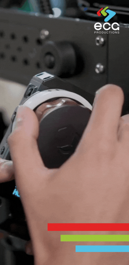 Close-up of a first AC’s hand pulling focus on a camera using a focus assist setup, illustrating the precision and skill involved in camera support for sharp, controlled shots.