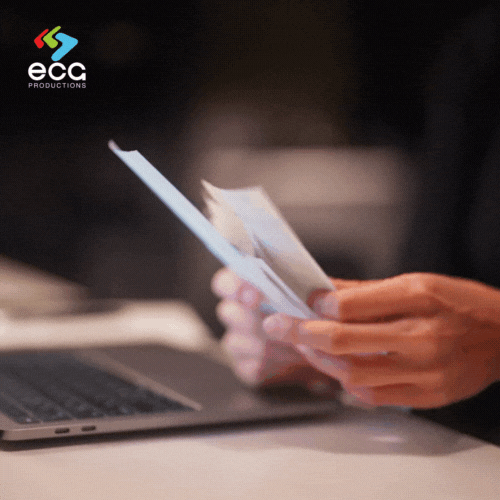 A line producer reviews receipts before entering them into the computer, showcasing the attention to detail needed for accurate expense tracking in line producing.