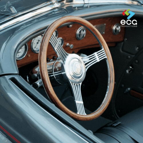 A close-up photo of a classic car interior, focusing on the elegant wood steering wheel, highlighting the attention to detail in automotive photography services.