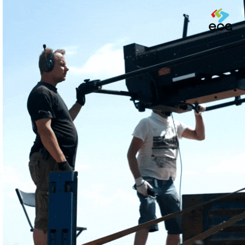 A crane operator collaborates with a rigging grip to practice a shot for a TV show, emphasizing the teamwork and technical skill involved in complex rigging setups.