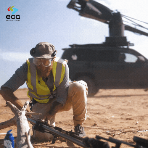 A rigging grip prepares a piece of equipment for a Russian arm, ensuring secure and smooth car shots, highlighting the technical expertise of rigging grips.