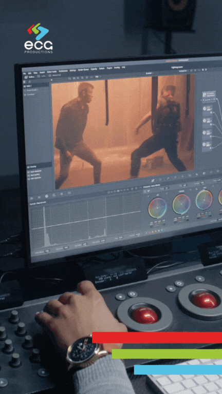Colorist working at a professional color grading console, adjusting tones and hues on a cinematic fight scene displayed on a monitor—demonstrating the precision and creativity involved in video color grading.