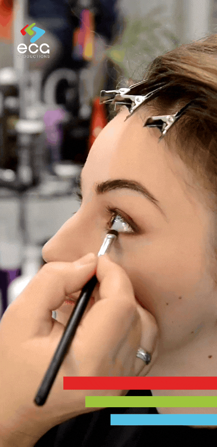 A woman getting eyeliner applied on set before a commercial shoot, showcasing the expertise and attention to detail of the hair and makeup team in ensuring on-camera perfection.