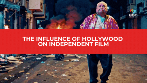 Man walking confidently through a gritty, chaotic urban street scene with fires burning in the background, overlaid by a bold red banner reading “The Influence of Hollywood on Independent Film”—illustrating how blockbuster aesthetics and dramatic storytelling have seeped into the indie film world.