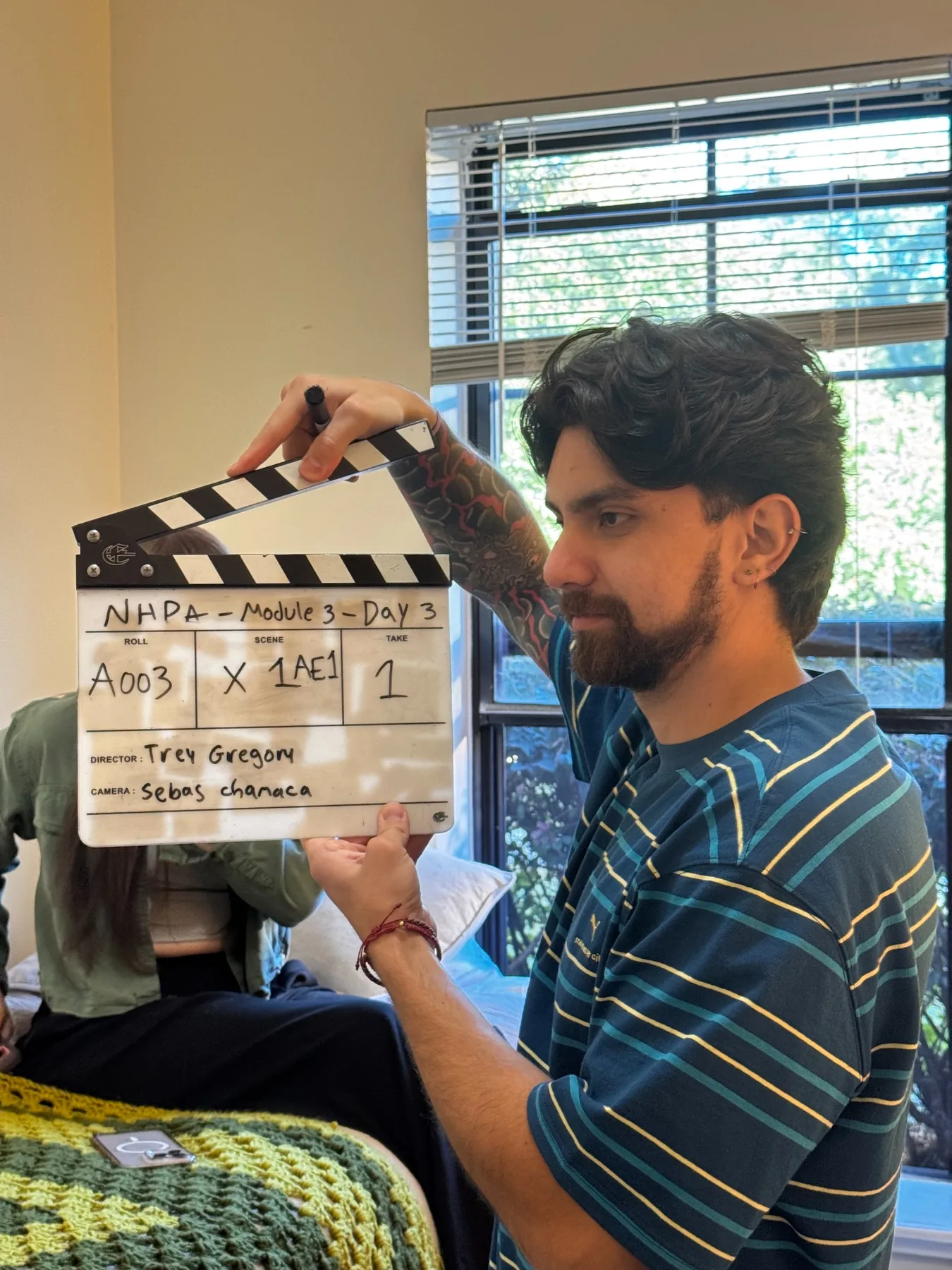 Crew member holding a production slate during filming for a 360-degree interactive VR module.