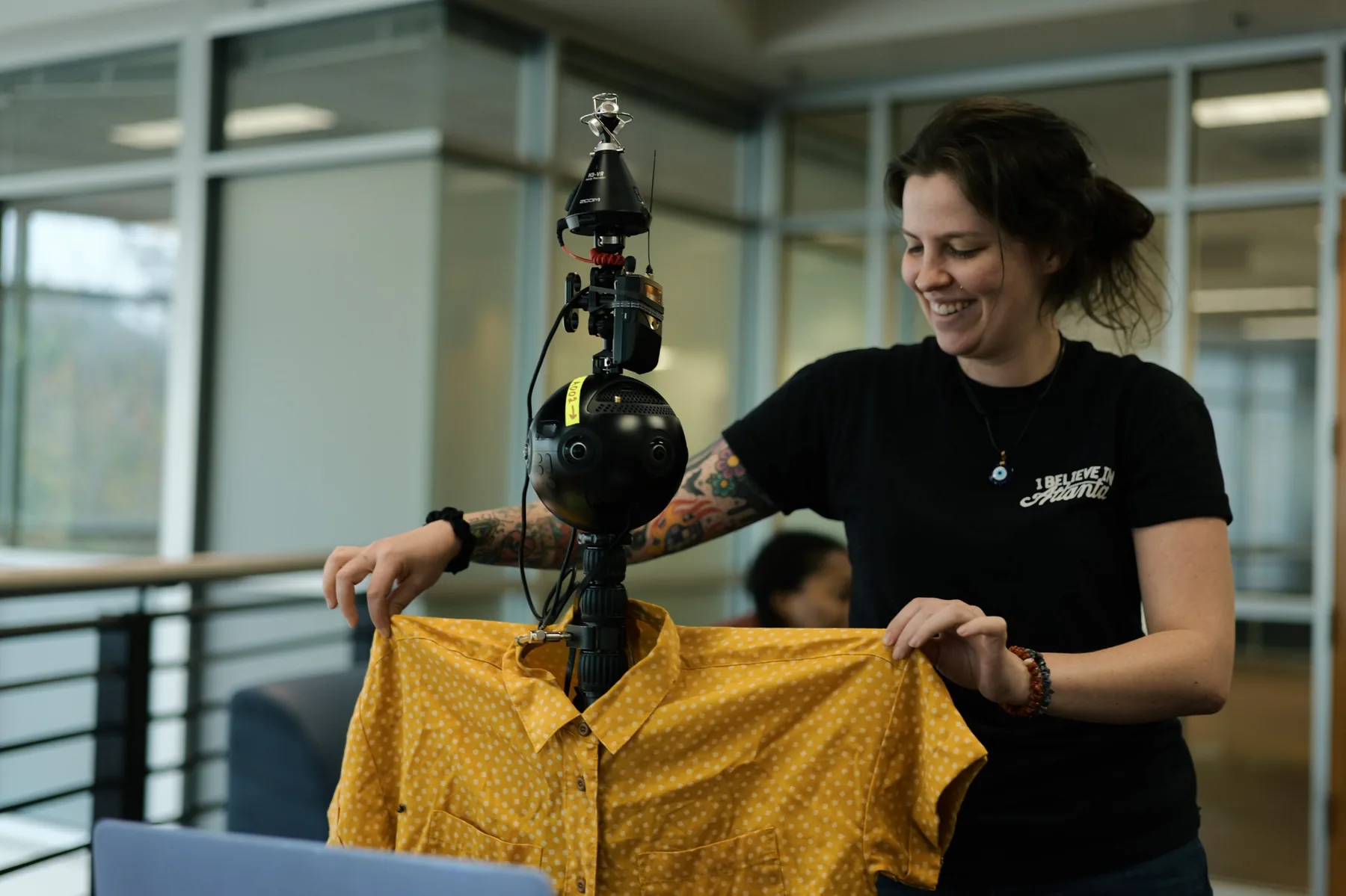 Crew member preparing wardrobe near a 360-degree camera rig for an immersive learning module.