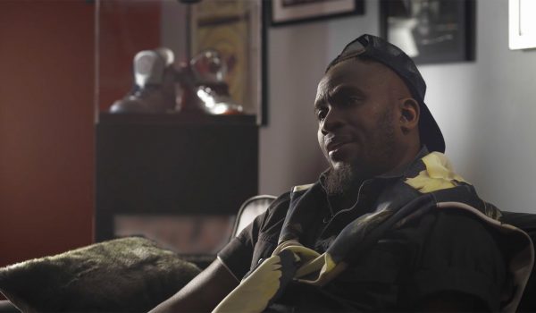 Anwan "Big G." Glover sits on a couch while filming some branded content for a mini-doc.