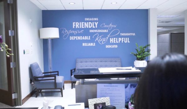 Hodges-Mace office lobby and waiting area with bluish purple wall full of positive and encouraging adjectives.