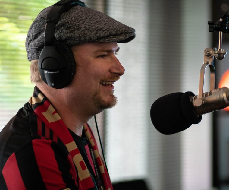 man-laughs-into-microphone-during-podcast-recording man laughs into microphone during podcast recording