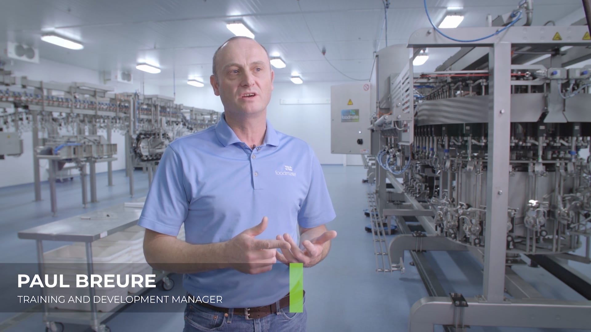 A man in a blue polo in a Foodmate production facility is filmed for a 2019 recruitment video.