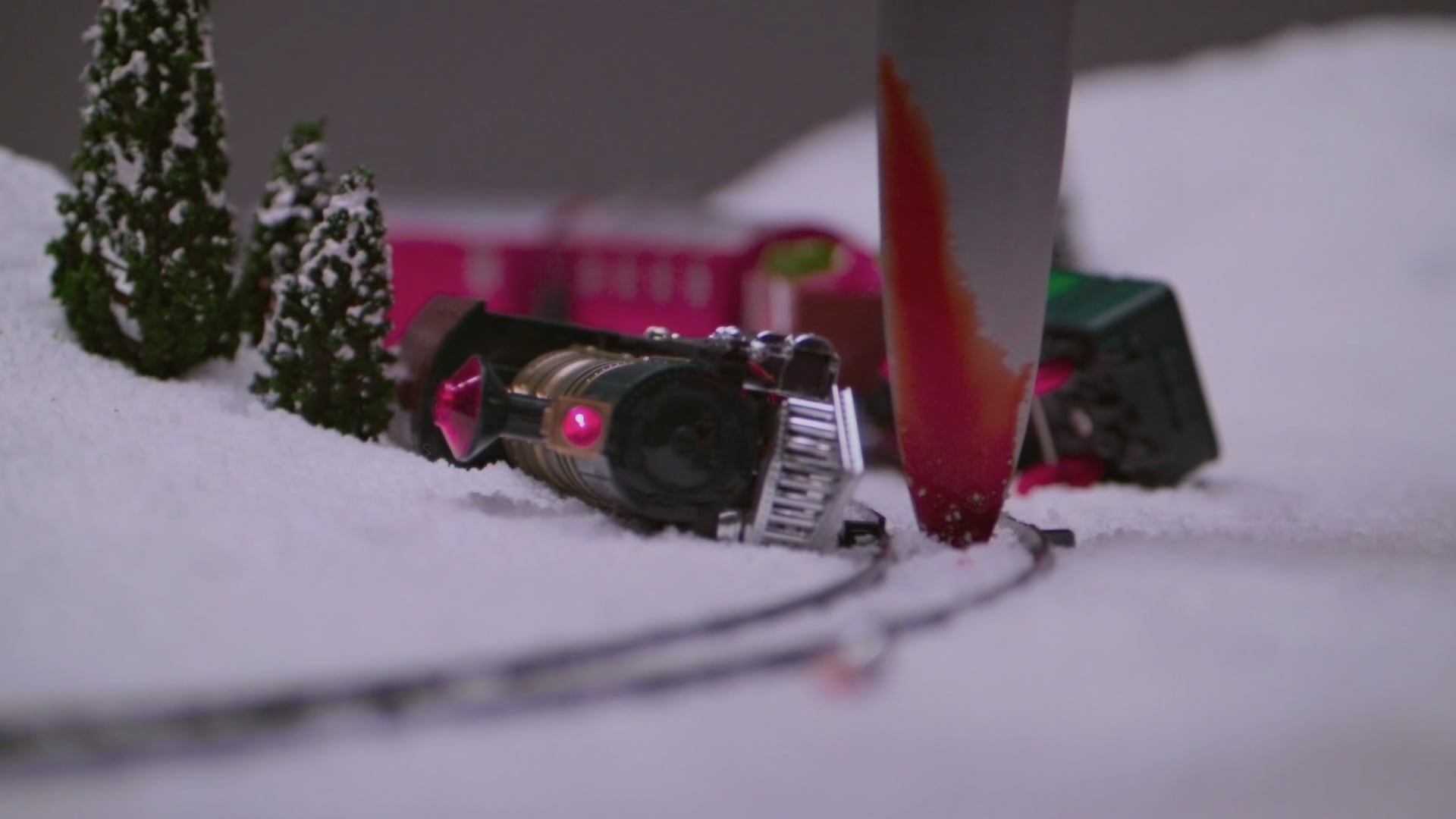 A trainwrecked model train surrounded by snow.