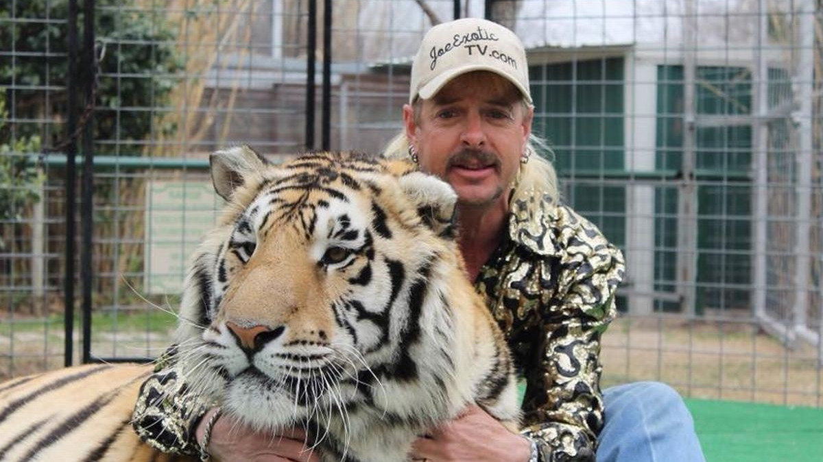 Joe Exotic, known as 'Tiger King,' poses with a tiger.